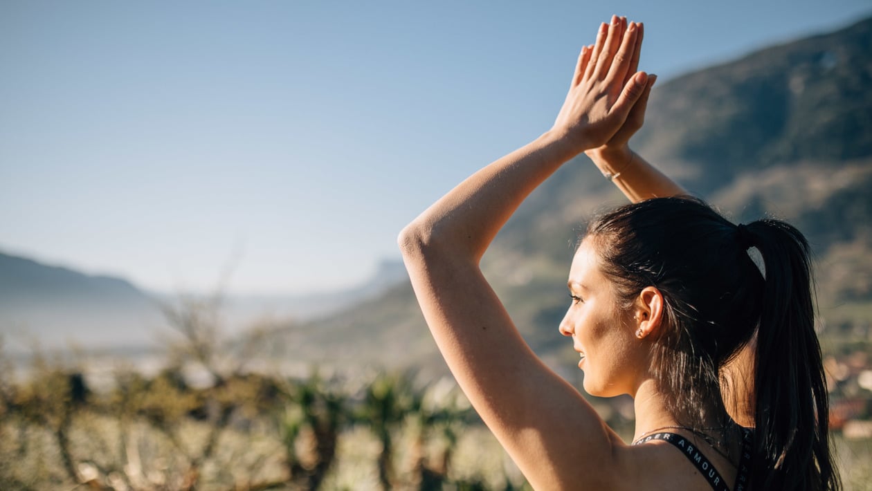 Donna che fa yoga al sole e all'aria aperta